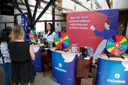 One of the sponsor booths, with people gathered in front of it talking to the sponsor.