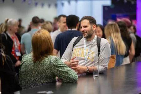 Two attendees chatting at the bar.