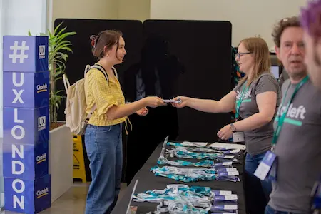 An attendee at the registration desk being handed her badge.