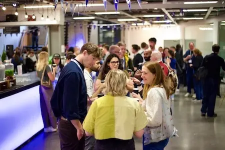 A group of people deep in conversation near the bar.