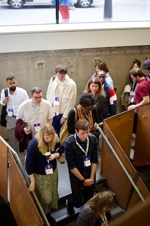 Attendees descending the staircase to the bar area.