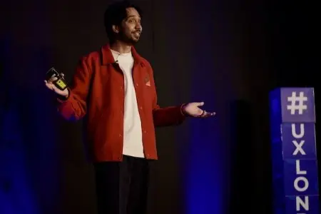 A man on stage speaking at UX London.