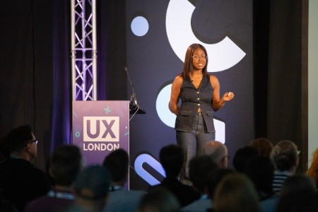 Tshili Ndou speaking on stage at UX London.