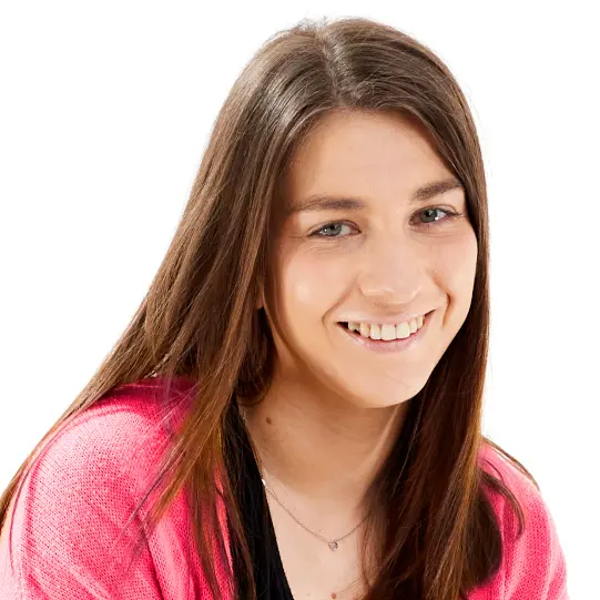 A smiling woman with long straight brown hair and a pink top.